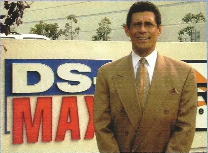 Photo of a younger Murray Reinhart standing in front of the DS-MAX logo.